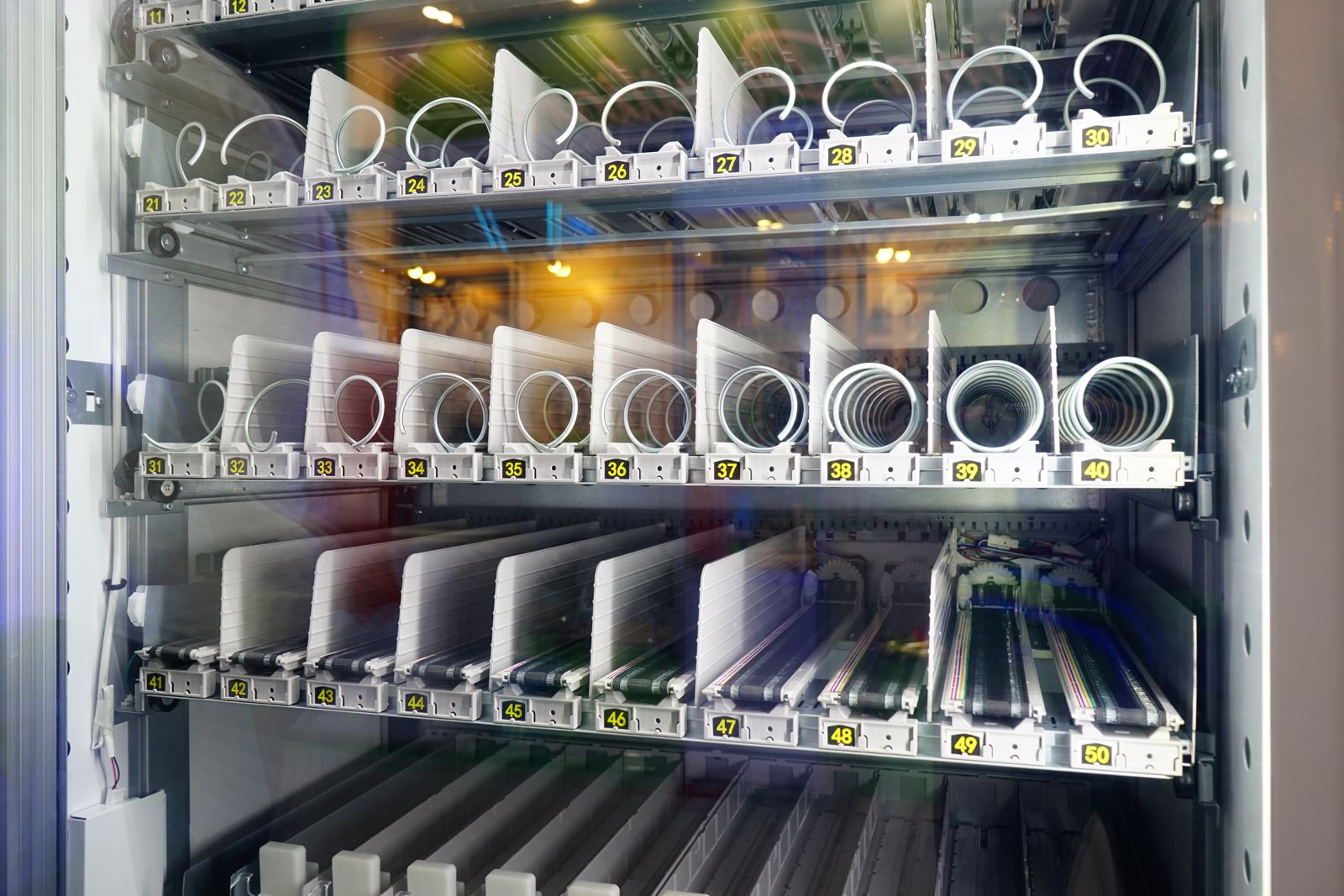Industrial tool-vending machine, drill bits held in numbered slots behind a transparent door