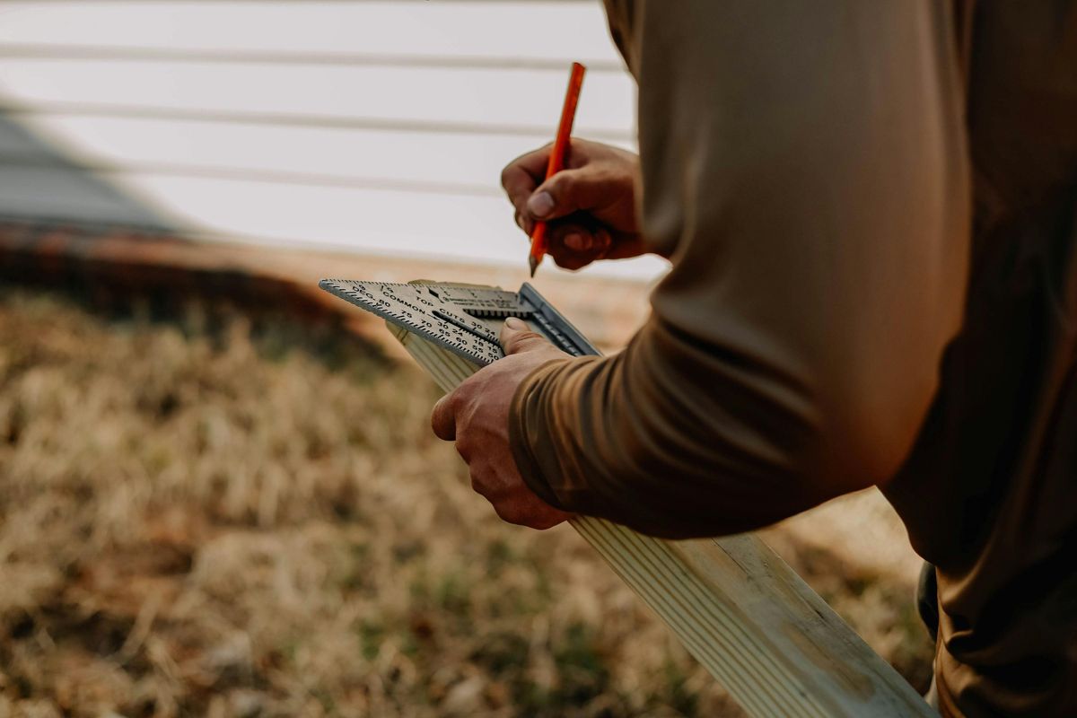Hands marking timber with a speed square — the craft of making things makeable
